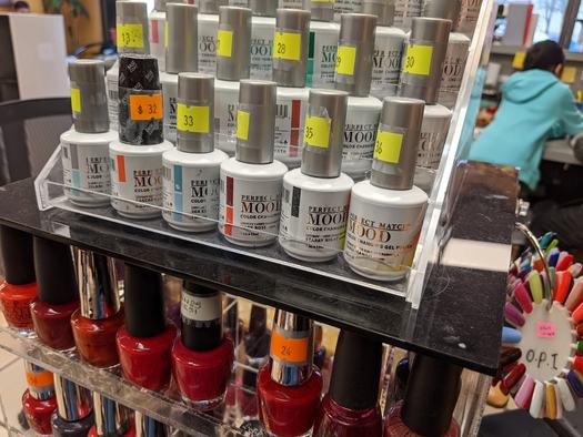 Nail polish and gel bottles racked at the nail station inside Salon 206