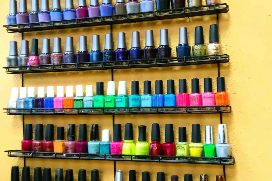 Wall rack of nail polish bottles inside Salon 206