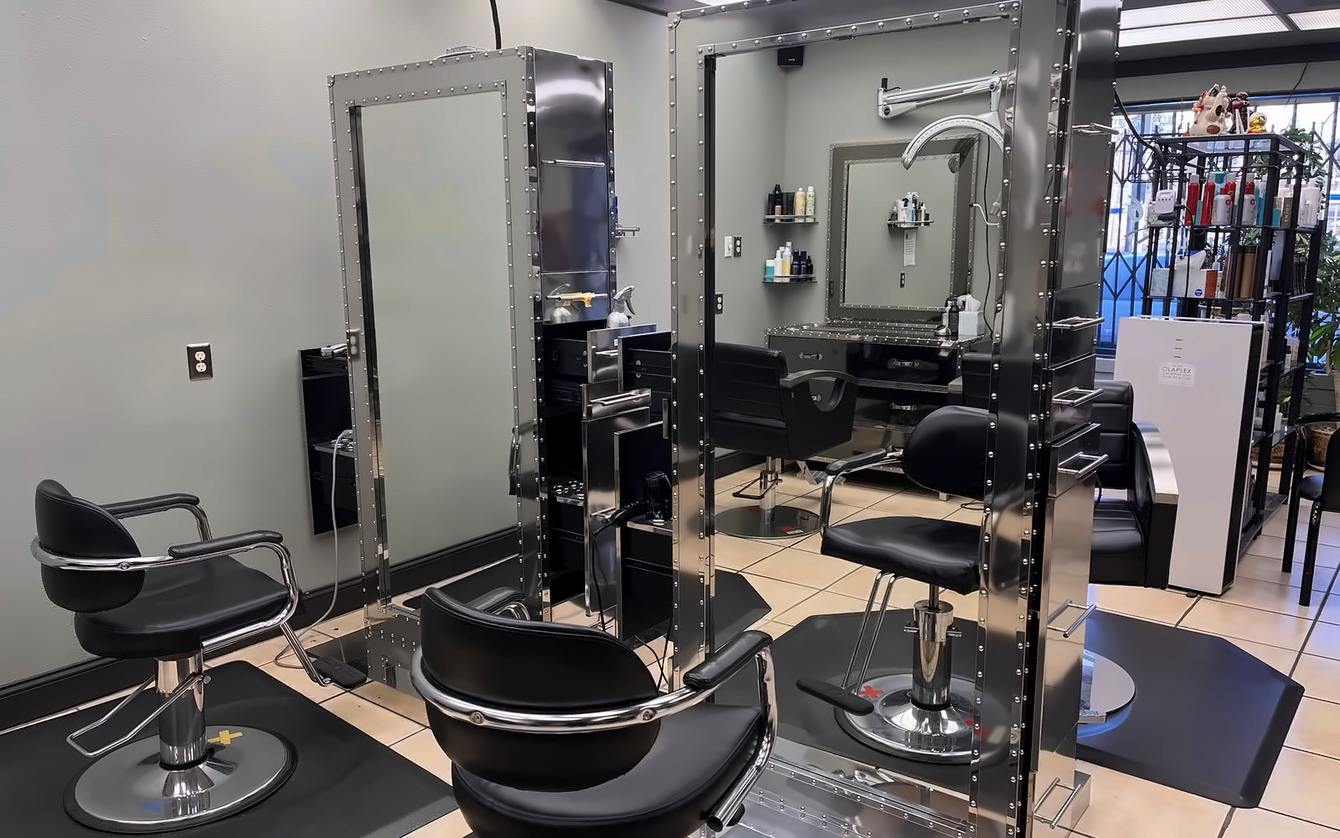 Steel styling stations and riveted mirrors on the salon floor at Salon 206